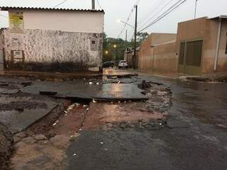 Na rua de cima, água levantou placas de asfalto (Foto: Aletheya Alves)