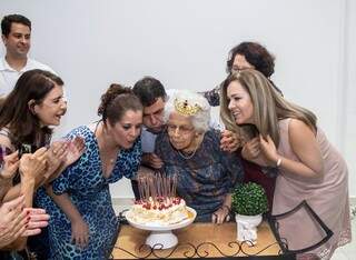 Dona Maria Athenice ao lado dos familiares soprando as velinhas de 100 anos. (Foto: Gustavo José Moisés)