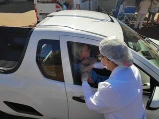 Dentro do carro, douradense é vacinada contra a gripe na abertura da campanha, nesta terça-feira (Foto: Adilson Domingos)