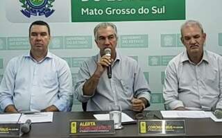 Reinaldo Azambuja (PSDB) no meio de secretários numa das transmissões ao vivo diária governo (Foto: Reprodução)