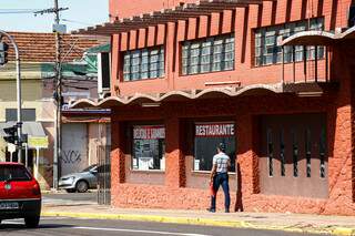 Pedestre passa em frente a restaurante fechado no Centro de Campo Grande. (Foto: Arquivo)
