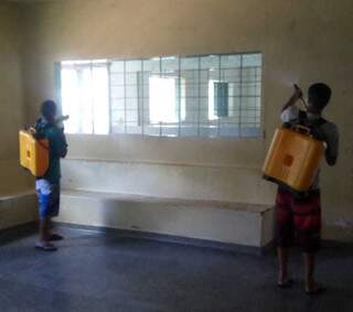 Dois adolescentes utilizando bombas costais para higienizar o interior da Unei Dom Bosco (Foto: Divulgação)
