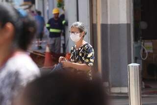Receosa com o contágio da doença, moradora usa máscara de proteção em pleno Centro da cidade. (Foto: Marcos Maluf)