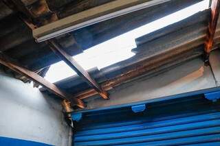 Telhado da loja foi quebrado por criminosos. (Foto: Henrique Kawaminami)