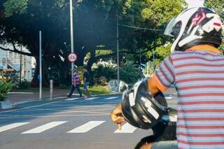 Motociclista na Avenida Afonso Pena, com pedestres ao fundo da via mais representativa da vida urbana em Campo Grande.