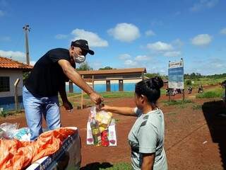 Mãe de aluno de escola indígena recebe kit de alimentos no município de Laguna Carapã (Foto: Divulgação)
