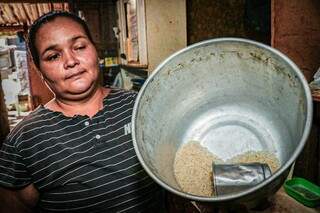 Esposa de Giuliano mostra vasilha de arroz. Alimento deve durar até sexta-feira. (Foto: Henrique Kawaminami)