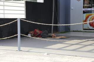 Morador dorme na calçada de estabelecimento em Campo Grande. (Foto: Kísie Ainoã)