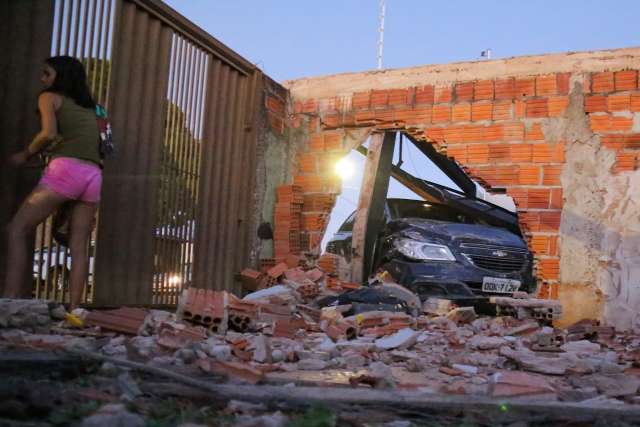 Carro é atingido durante ultrapassagem e derruba muro de residências