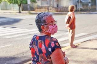 Em calçada da Capital à espera da vacina contra a gripe, idosa usa máscara para se proteger de novo vírus (Foto: Paulo Francis/Arquivo)