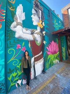 A artista plástica, Luana Fumagalli na frente do mural que pintou. (Foto: Arquivo pessoal)
