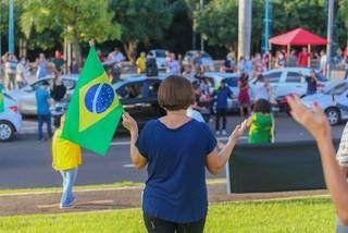 Mulher segura bandeira do Brasil enquando faz oração na Afonso Pena (Foto: Marcos Maluf)