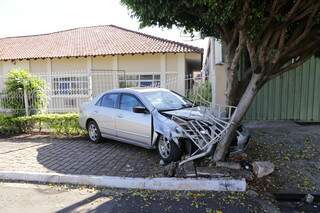 Desgovernado na descida, carro derruba grade de casa e para ap&oacute;s bater em &aacute;rvore