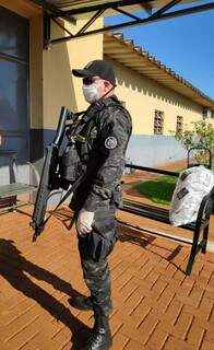 Policial com equipamentos de segurança em frente ao semiaberto de Dourados na terça-feira (Foto: Divulgação)
