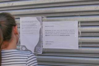 Quem procurou por unidade da C&amp;A na Rua Marechal Rondon, no Centro da Capital, encontrou apenas papéis com aviso. (Foto: Marcos Maluf)