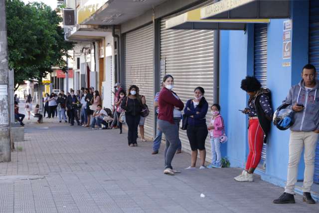 Desempregados viram a noite e cochilam na cal&ccedil;ada &agrave; espera do seguro