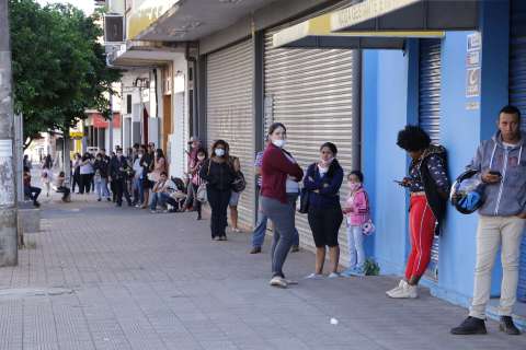 Desempregados viram a noite e cochilam na calçada à espera do seguro