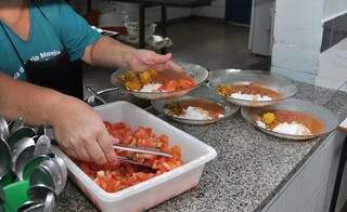 Merendeira serve pratos de alunos em centro de educação infantil de Dourados antes da paralisação das aulas (Foto: Divulgação)