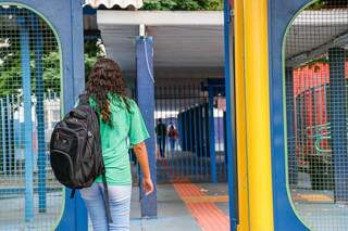 Aluna da rede estadual entra na Escola Joaquim Murtinho no último dia das aulas presenciais (Foto: Henrique Kawaminami)