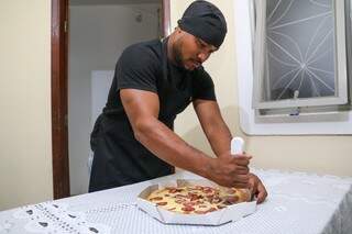 O pizzaiolo cortando as fatias da pizza de calabresa antes da entrega. (Foto: Paulo Francis)