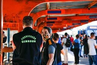Fiscais da Semadur em terminal de ônibus de Campo Grande (Foto: Henrique Kawaminami)