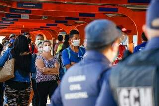 Passageiros usam máscara, item obrigatório, enquanto aguardam transporte coletivo (Foto: Henrique Kawaminami/Arquivo)