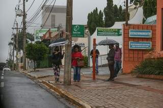 Campo-grandenses prevenidos usam guarda-chuva para se proteger (Foto: Paulo Francis)