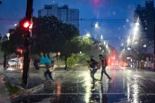 Pedestres tentam se protejer com toalhas ou apressam os passos para tentar escapar da chuva   (Henrique Kawaminami) 