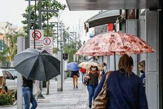Guarda-chuva e máscara são os acessórios do dia (Foto: Henrique Kawaminami)