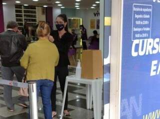 Funcionária do shopping mede a temperatura corporal de cliente no acesso ao shopping de Dourados (Foto: Divulgação)