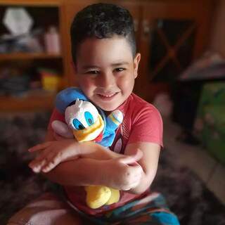 Aos 4 anos, Felipe não escondeu a alegria ao receber o Pato Donald de pelúcia. (Foto: Arquivo pessoal)