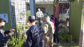 José Carlos Acevedo com policiais e equipes de saúde no portão de sua casa (Foto: Marciano Candia/Última Hora)