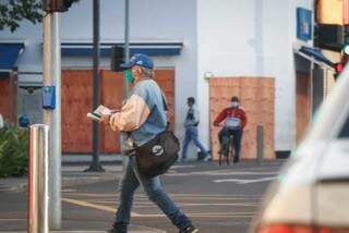 Pedestre caminhando usando máscara de proteção no Centro da cidade. (Foto: Henrique Kawaminami) 
