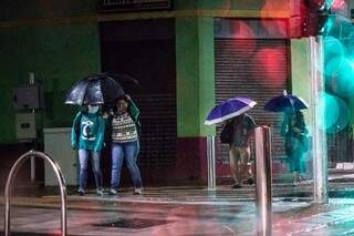 Quem madrugou para trabalhar dividiu o guarda chuva na manhã sem sol em Campo Grande (Foto: Henrique Kawaminami)