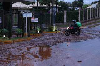 Rua sem asfalto leva sujeira e lama para frente de condomínio e causa transtorno Rua sem asfalto leva sujeira e lama para frente de condomínio e causa transtorno