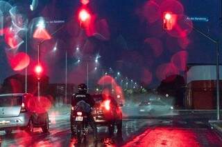 Neon nas luzes do trânsito e do farol com a chuva nesta manhã na Avenida das Bandeiras em Campo Grande (Foto: Henrique Kawaminami)