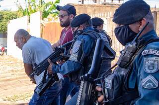 Cleber (de camisa cinza) na casa onde o 7º corpo foi encontrado no sábado (16), na Rua Netuno, na Vila Planalto (Foto: Kisie Aionã)