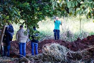 Cleber de Souza Carvalho, de camiseta azul, dá indicação sobre onde enterrou uma de suas 7 vítimas. (Foto: Henrique Kawaminami)