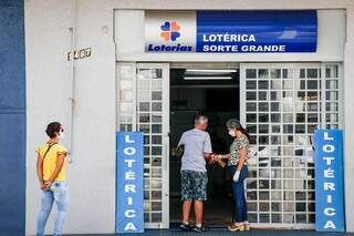Clientes buscando atendimento em lotérica da Capital. (Foto: Henrique Kawaminami) 