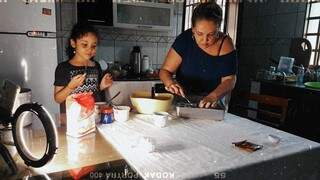 Maria Celícia, de 10 anos, ao lado da mãe Cíntia Castanheira, aprendendo a fazer os muffins da avó Terezinha, que está em isolamento. (Foto: Anderson Benites)