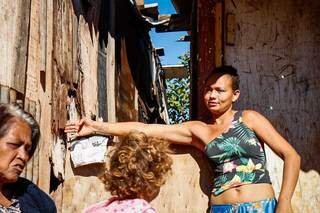 Com o braço, Yasmin mostra o distanciamento entre os barracos na Favela do Mandela: &#34;coisa de TV&#34; (Foto: Henrique Kawaminami)