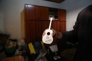 Vandir segurando um violão pequeno de enfeite com o nome do Grupo Acaba. (Foto: Marcos Maluf)