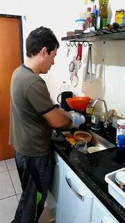 Eder Allis Nantes lavando a louça que está na pia da cozinha. (Foto: Arquivo pessoal)