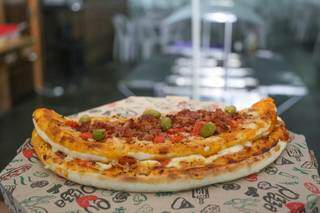 Pizza dobrada recheada com cheddar, azeitona, tomate e muito bacon. (Foto: Paulo Francis)