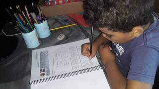 O aluno João Victor Bezerra Campos respondendo o caderno de atividades da escola. (Foto: Arquivo pessoal)