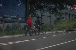Pedestres agasalhados empurram as bicletas na Avenida Ceará (Foto: Henrique Kawaminami)