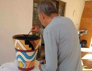 Chico pintando vasos em casa. (Foto: Carina Cury)