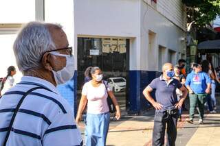 Pessoas com máscara andam pelas ruas de Campo Grande. (Foto: Kisie Ainoã)