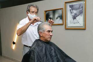 João cortando o cabelo do governador Reinaldo Azambuja, na tarde dessa segnda-feira. (Foto: Kísie Ainõa)