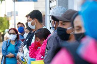 Máscaras e olhares distantes na fila da Funtrab (Foto: Henrique Kawaminami)